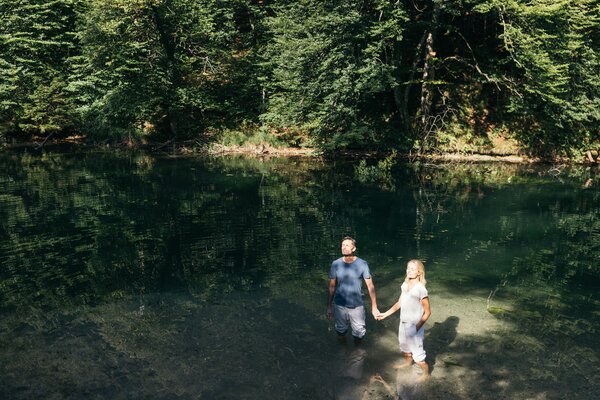 Paar steht in der Sonne und hält Händchen im Wasser